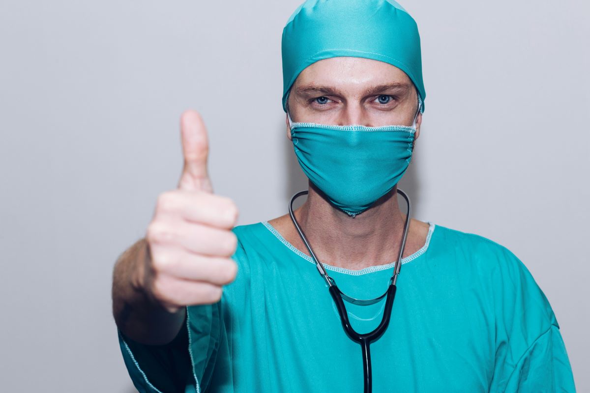Picture of a Doctor in Scrubs holding his thumb up