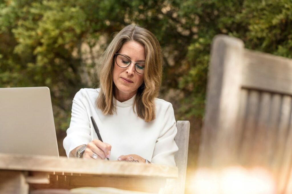 Women sitting at a table writing a cover letter for a job.